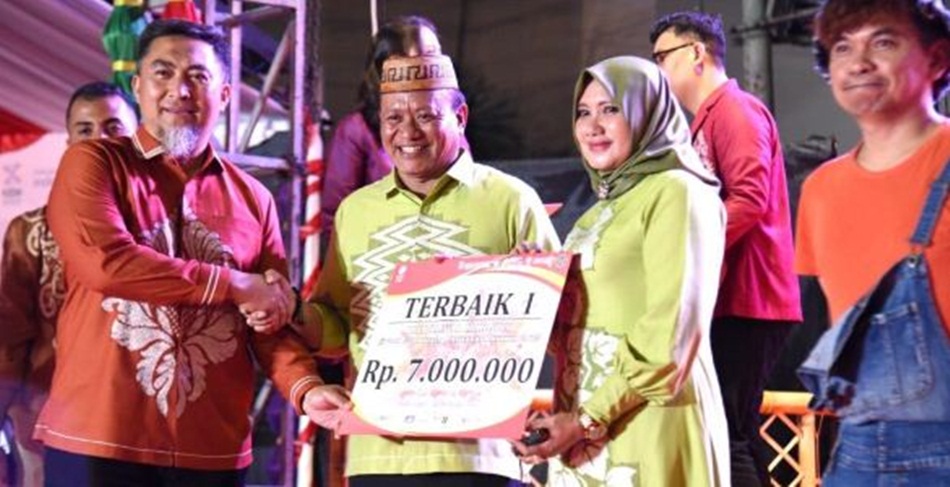 Penjabat Sekdaprov Gorontalo Budiyanto Sidiki saat menyerahkan hadiah  kepada pemenang lomba Gorontalo Karnaval Karawo yang diraih oleh  Diskomperindag Provinsi Gorontalo. (Foto &ndash; Haris)