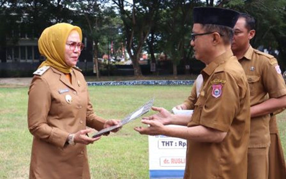 dr. Rusli Katili saat menerima SK pensiun yang diserahkan oleh Wakil Bupati Merlan S. Uloli, disela-sela apel kerja di lingkungan Pemkab Bone Bolango, di halaman Kantor Bupati (F.AKP/Diskominfo)
