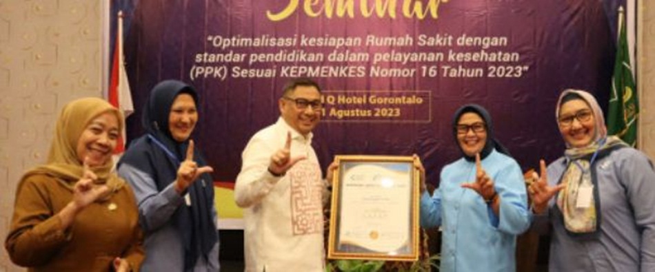 Direktur LAM-KPRS, dr. Andi Wahyuningsih Attas, Sp.An., TI, Subspes.T.I.(K), MARS menyerahkan akreditasi Parpurna RSUD Toto Kabila kepada Bupati Bone Bolango, Hamim Pou, di Grand Q Hotel Kota Gorontal