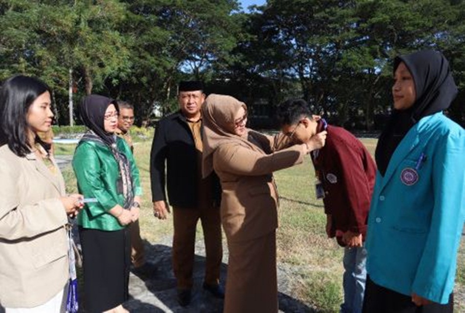 Asisten III Marni Nisabu saat menyematkan tanda peserta magang bersertifikat kepada perwakilan mahasiswa program Magang  Bersertifikat Pertanian Konservasi MSIB angkatan 5 tahun 2023,  (AKP/Kmfo)