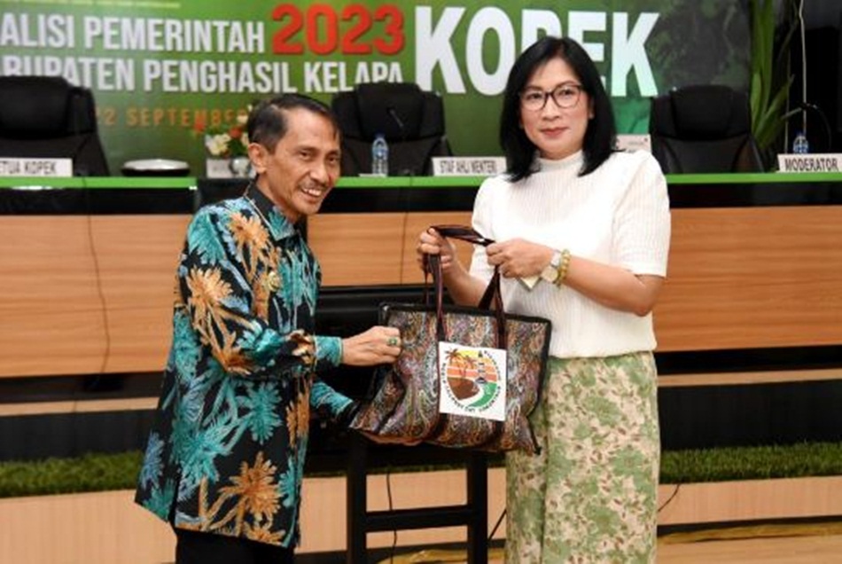Bupati Gorontalo Nelson Pomalingo, selaku Ketua Kopek menyerahkan bingkisan kepada Direktur Eksekutif ICC, Jelfina Alouw, pada Rakernas Kopek II di Ruang Madani, Kantor Bupati Gorontalo.(F:haris)
