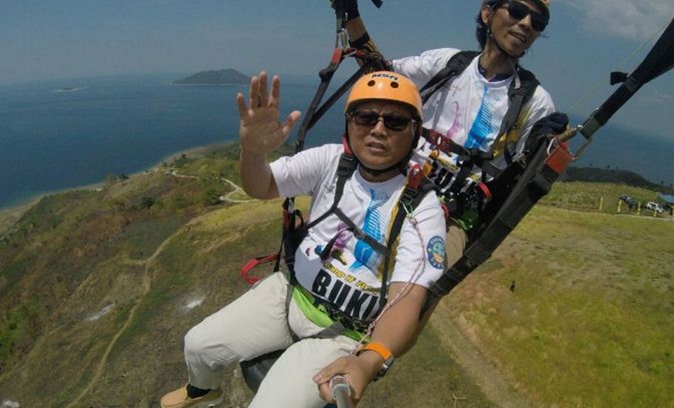 Bupati Gorontalo Utara Thariq Modanggu menikmati olah raga para layang di Puncak Bukit Dunu Ceria memperingati Hari Pariwisata se-Dunia Tahun 2023(dokumentasi Bupati Thariq)