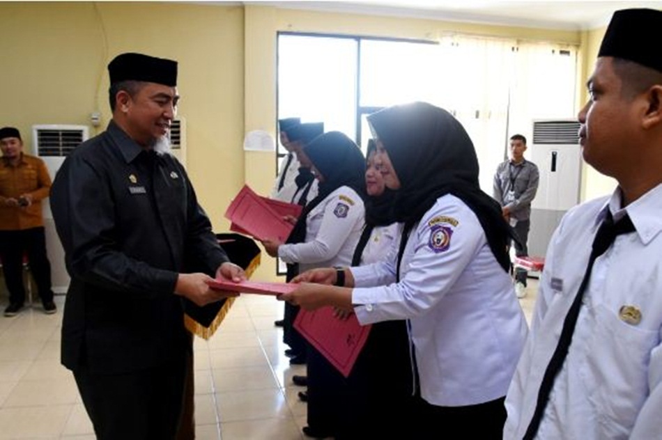 Penjabat Sekdaprov Gorontalo, Budiyanto Sidiki, menyerahkan SK kepada PPPK guru yang dilantik di aula kantor BKD Provinsi Gorontalo, Selasa (3/10/2023). (Foto : Haris)