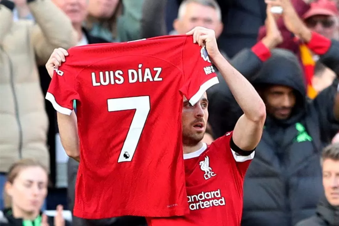 Diogo Jota membentangkan jersey milik rekannya, Luis Diaz, untuk memberikan dukungan dan berharap agar penculik ayah Diaz segera membebaskannya. (Sumber: REUTERS/Scott Heppell)
