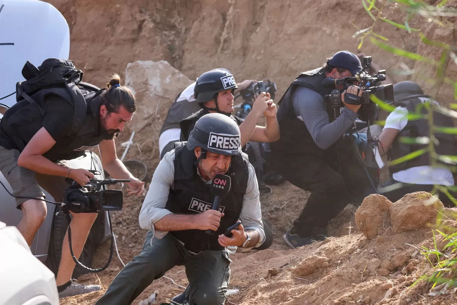Para reporter yang menghindar saat mendengar sirine peringatan roket yang akan meluncur ke Gaza. (cpj.org (AFP/Jack Guez)