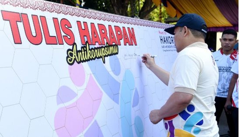 Penjagub Ismail Pakaya menuliskan harapan  antikorupsi pada pencanangan kegiatan   Hakordia  tahun 2023 tingkat Provinsi Gorontalo di Lapangan  Taruna Remaja, Kota Gorontalo, (Foto : Haris)