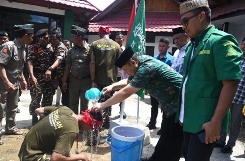Baiat ditandai dgn penyiraman air kembang oleh Penjagub Ismail Pakaya kepada peserta  PKL SUSBALAN Pimpinan wilayah GP Ansor Provinsi Gorontalo, yang berlangsung di Pentadio Resor.( Foto:Haris)
