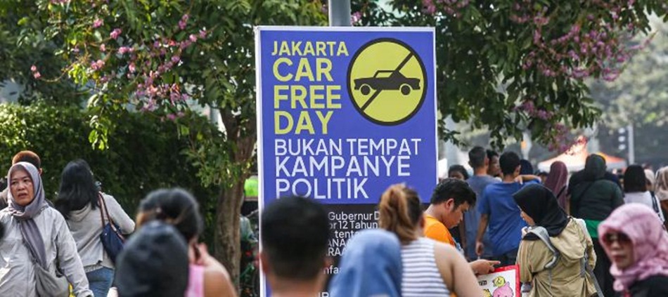 Warga beraktivitas di dekat poster peringatan larangan kampanye politik saat Hari Bebas   Kendaraan Bermotor atau Car Free Day (CFD) di Kawasan Bundaran HI, Jakarta, .  (MIFTAHUL HAYAT/JAWA POS)
