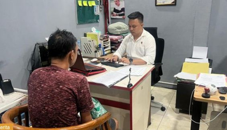 Pelaku oknum honorer saat menjalani pemeriksaan Satreskrim Polresta Gorontalo Kota.(F:hms-pol)