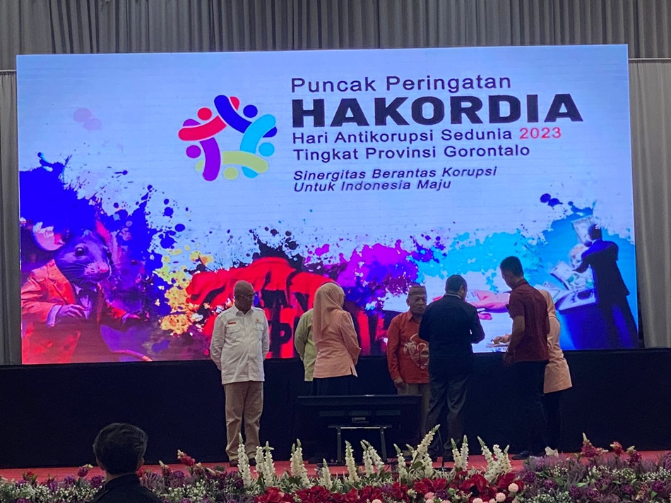 Penjagub Gorontalo Ismail Pakaya saat menyematkan Pin Anti Korupsi, pada puncak Peringatan Harkordia Tahun 2023 tingkat Provinsi Gorontalo, bertempat di Grand Palace Convention Center. (Foto &ndash; Upind)