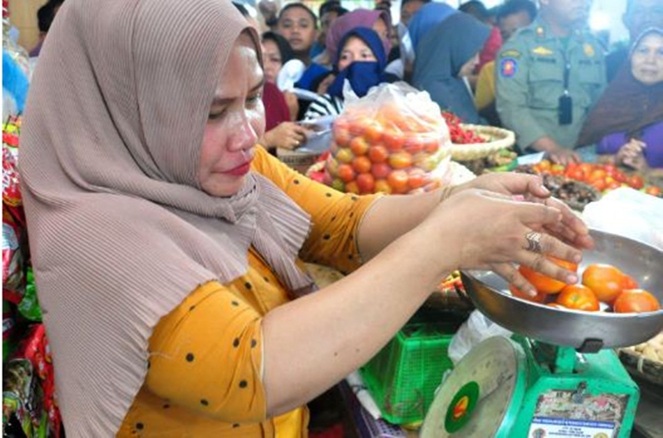 Seorang pengecer menimbang tomat yang dibeli warga pada pasar murah yang digelar   Pemprov Gorontalo di Pasar Sentral Kota Gorontalo (Foto : Haris)