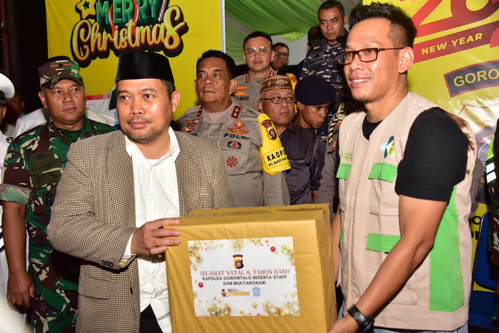 Tinjau Posko pengamanan Natal dan tahun baru Penjagub Gorontalo Ismail Pakaya menyerahkan bingkisan kepada petugas  di Simpang Lima, Telaga, Kabupaten Gorontalo, (Foto &ndash; Fadil)