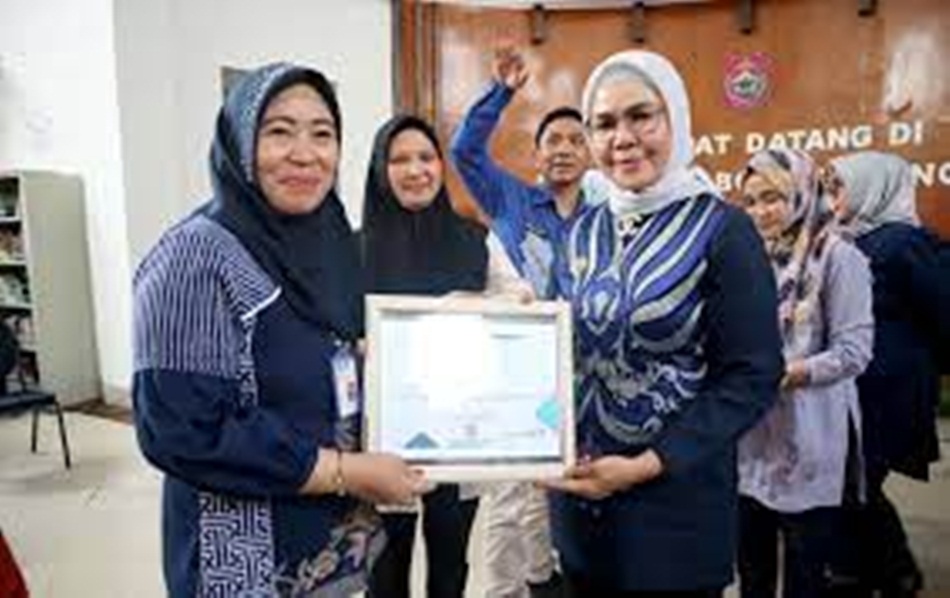 Bupati Merlan S. Uloli menyerahkan piagam penghargaan kepada Kepala Diskominfo Bone Bolango Misnawaty Wantogia, pada acara penyerahan penghargaan ASN Award tahun 2023. (F.AKP)