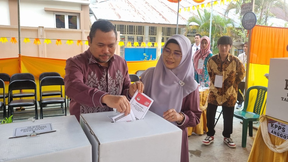 Penjagub Ismail Pakaya bersama Fima Agustina saat mengisi kertas suara usai mencoblos di TPS 001 di Kelurahan Biawao, Kecamatan Kota Selatan, Kota Gorontalo. (Foto : Fadhly)