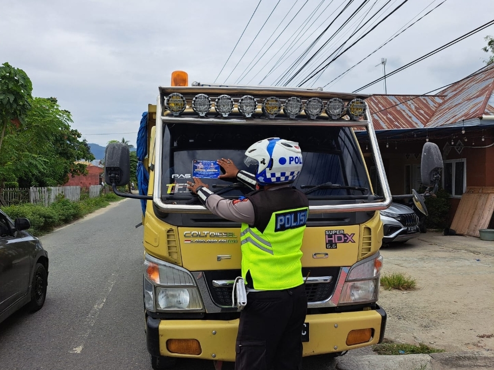 Anggota Satlantas Polres Bone Bolango saat menempel stiker di salah satu kendaraan (F:Hms-pol)