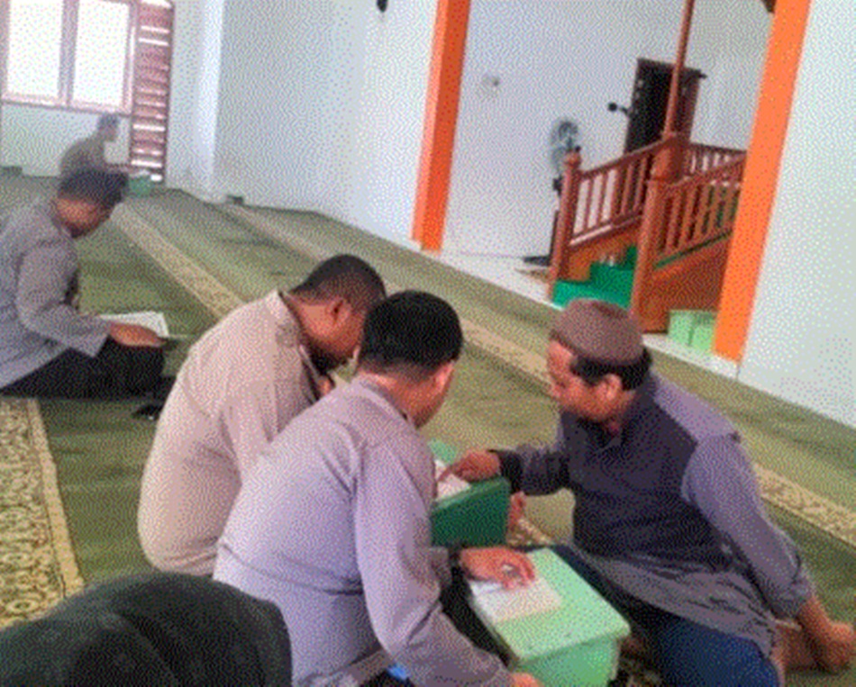 Anggota Polres Gorontalo Kota saat menjalankan sanksi membaca Alquraan usai   melakukan pelangaran tak ikut apel.(F:Hms-pol)