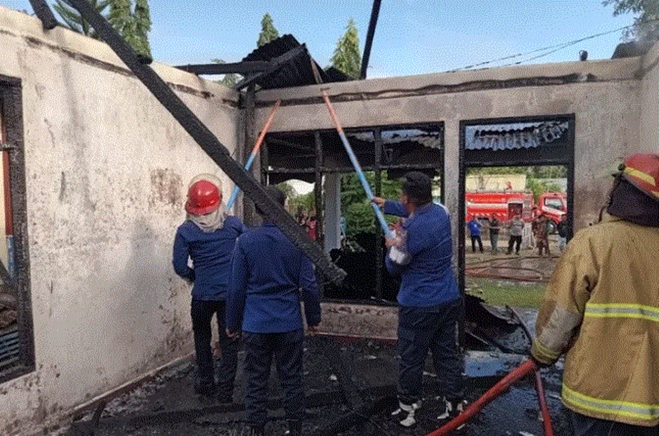 Tim Damkar Kabupaten Gorontalo tengah berupaya memadamkan api yang membakar dua rumah di Pentadio Barat, Kecamatan Telaga Biru, Kabupaten Gorontalo. (F:ist)