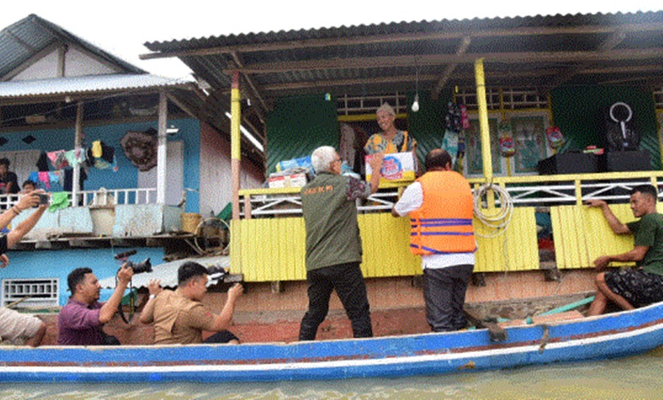 dengan menggunakan perahu Pj Gubernur serahkan bantuan kepada korban banjir (F:Kmfo)