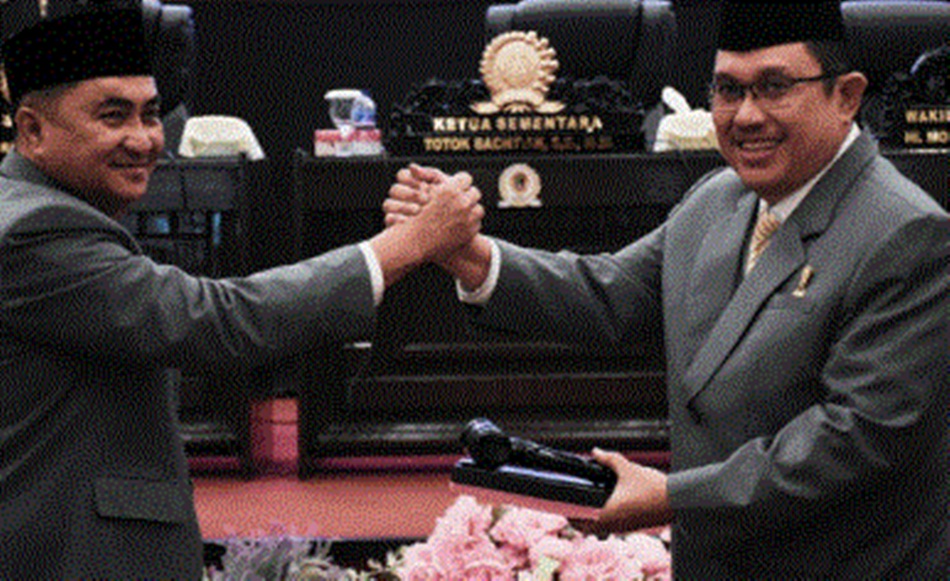 Ketua DPRD Kota Gorontalo, Hardi Sidiki, saat menyerahkan Palu Sidang kepada Totok  Bachtiar, Ketua DPRD Kota Gorontalo Sementara.(Foto:GP)