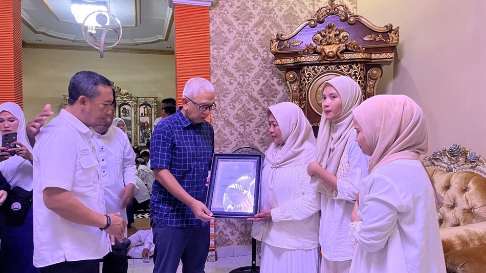 Pj Gubernur Gorontalo Rudy Salahuddin saat memberikan Piagam Pahlawan Olahraga   kepada Almarhum Harsono A. Taha yang diwakili oleh istri Almarhum atas kontribusi besarnya  olahraga takraw. (F: Isam)