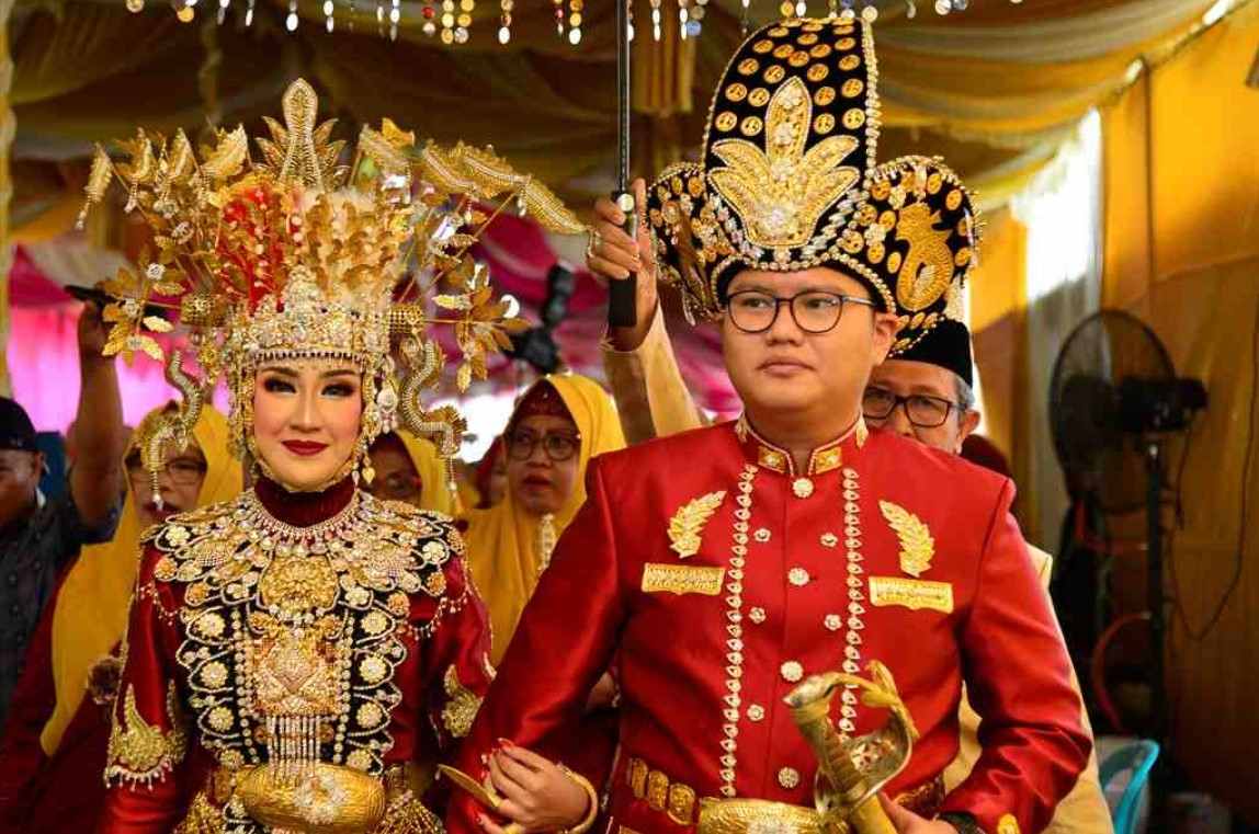 seorang pria menggunakan pakaian adat makuta