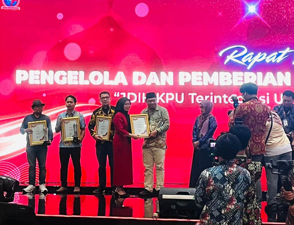 Anggota KPU Provinsi Gorontalo Divisi Hukum dan Pengawasan, Risan Pakaya saat menerima penghargaan. (F:humas).