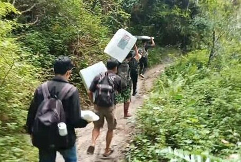ogistik Pilkada dengan cara dipikul menuju dudun Waolo, Desa Molotabu,   Kecamatan Kabila Bone, Kabupaten Bone Bolango. (Foto : humas)