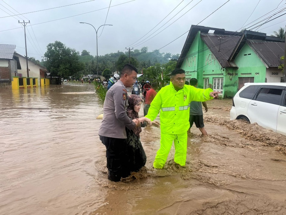 Jajaran Polres Boalemo saat membantu warga yang terdampak banjir.(F:hms-Pol).