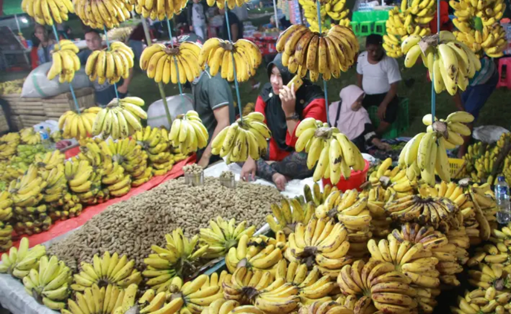 Pedagang menjual pisang dan kacang di pasar malam pada tradisi Malam Qunut di Desa Payunga, Kec. Batudaa, Kab. Gorontalo.