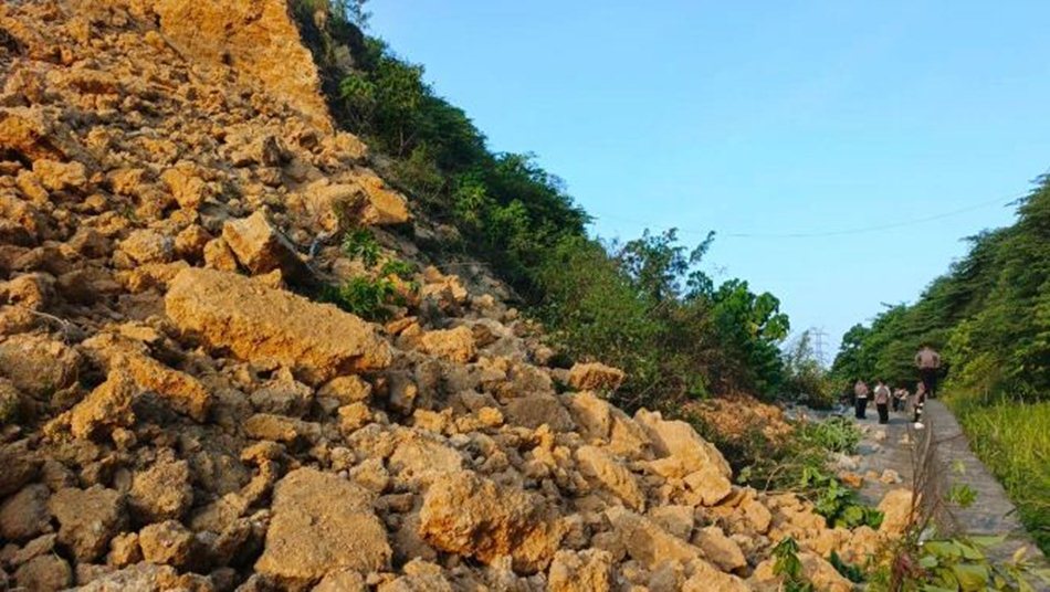 Tanah dan batu dalam jumlah besar menutupi hampir seluruh badan jalan, sehingga  kendaraan tak bisa melintas. .(F:ist)