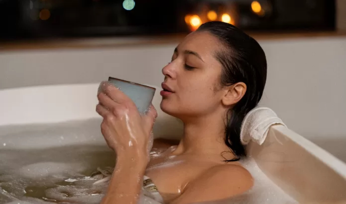 lustrasi seorang perempuan yang sedang berendam di bath tub pada malam hari. (Freepik)
