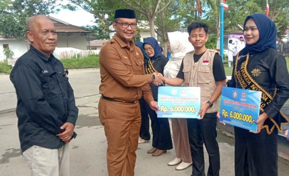Staf Ahli Gubernur Bidang Pemerintahan, Hukum, dan Politik, Masran Rauf,   menyerahkan secara simbolis bonus ke pemuda pemudi berprestasi pada upacara  peringatan Hari Sumpah Pemuda ke-97. (F:Ist)
