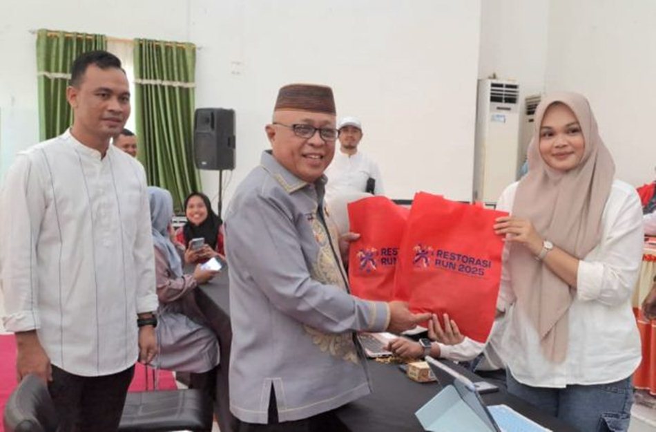 Bupati Gorontalo, H. Sofyan Puhi.  Tampil sebagai peserta pertama yang mengambil Race Pack Collection (RPC) untuk ajang Restorasi Run 2025. (F:Kmfo)