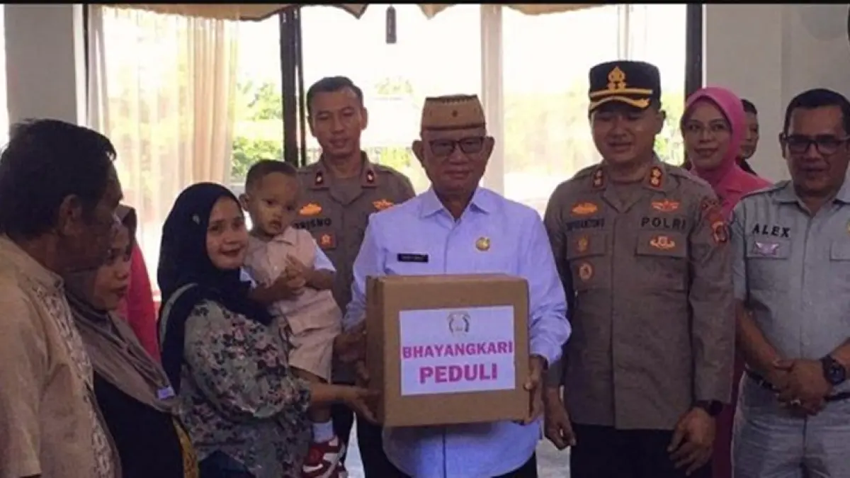 Bupati Ismet Mile saat menyerahkan paket bantuan kepada masyarakat. (F.Indra/Diskominfo)