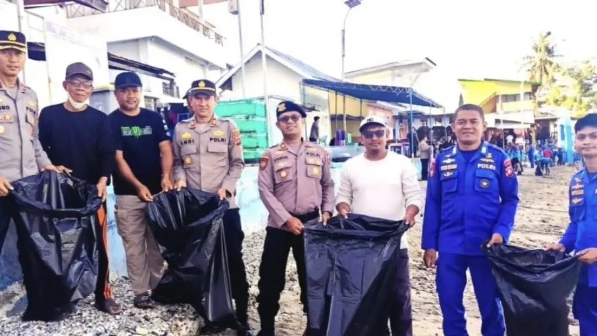 Personel Polri dan masyarakat disela kegiatan bersih-bersih pantai kawasan Wisata Hiu Paus, Desa Botu Barani, Kecamatan Kabila Bone, Kabupaten Bone Bolango, Provinsi Gorontalo, Senin (6/7/2026). (ANTARA/Zulkifli Polimengo)