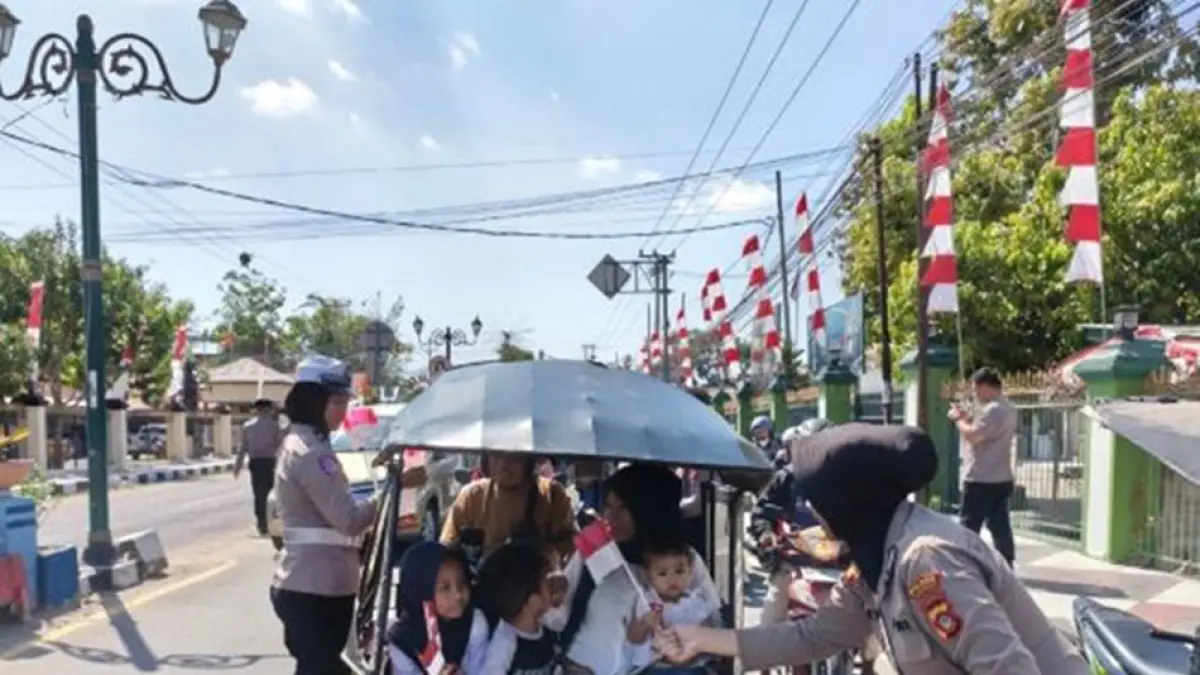 Sejumlah personel Polisi Wanita (Polwan) Polres Gorontalo turun menyapa masyarakat sekaligus membagikan Bendera Merah Putih kepada para pengguna  jalan.(F:Hms-Pol)