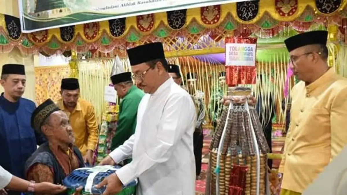Bupati Boalemo Rum Pagau didampingi Wakil Bupati Lahmudin Hambali  menyerahkan bantuan saat menghadiri menghadiri perayaan Maulid Nabi Muhammad SAW secara tradisional di mesjid Agung Baiturrahmah.(F:Diskominfo)
