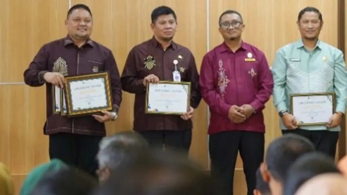 Kepala BKAD Kabupaten Gorontalo, Hariyanto Manan(paling kiri) saat menerima penghargaan dari KPPN Gorontalo.(F:Diskominfo)
