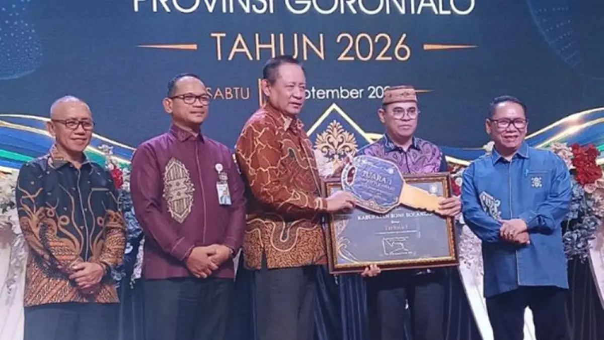 Gubernur Gorontalo Gusnar Ismail yang didampingi Kepala BPJS saat menyerahkan penghargaan kepada Sekda Bone Bolango Dr. Iwan Mustapa.(F:Istimewa)