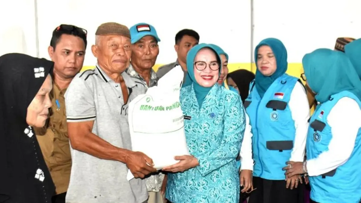 Ketua TP-PKK Kabupaten Gorontalo Maryam Sofyan Puhi saat menyerahkan bantuan Cadangan Pangan Pemerintah (CPP) kepada masyarakat. di Kecamatan Limboto Barat.(F:Diskominfo)
