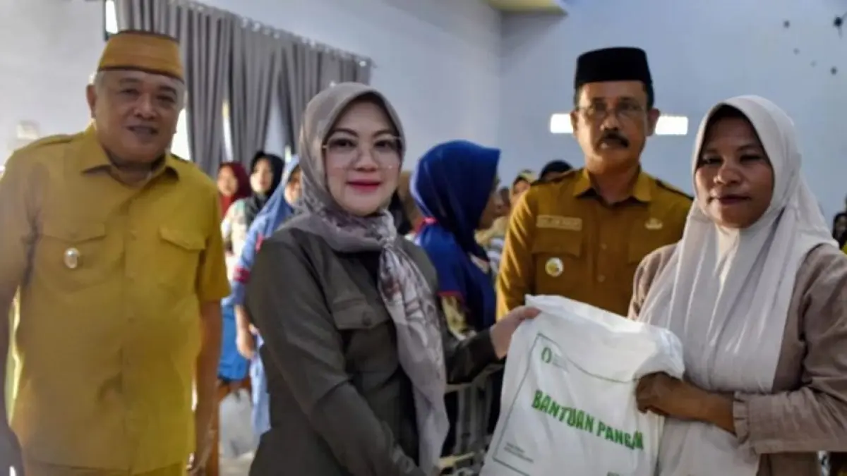 Didampingi Wakil Bupati Wakil Ketua TP. PKK Kabupaten Gorontalo, Ny. Venny Junus Anwar. menyerahkan bantuan program Cadangan Pangan Pemerintah (CPP).(F:Diskominfo)