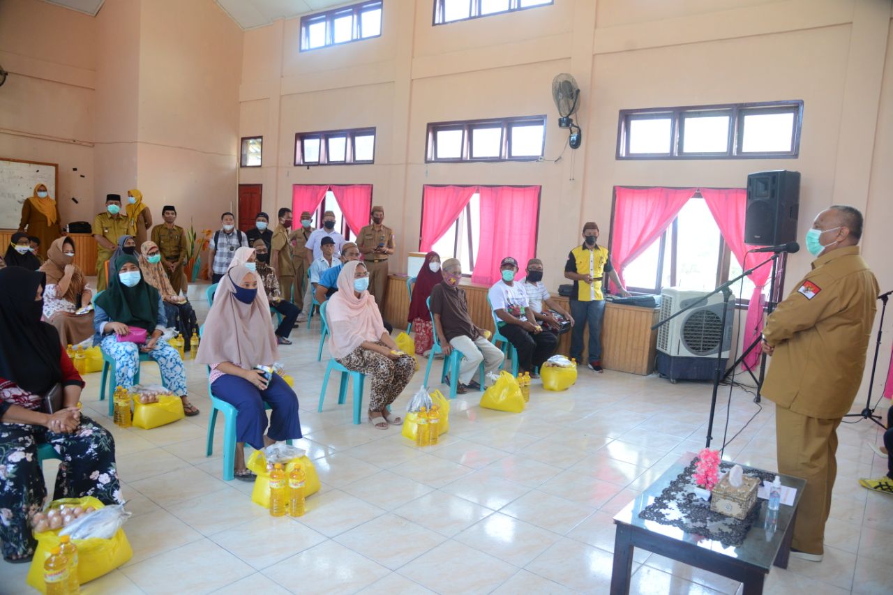 Gubernur Gorontalo Rusli Habibie saat berfoto bersama masyarakat perwakilan penerima bantuan pangan bersubsidi Baksos NKRI Peduli bagi warga terdampak covid-19 di Kec.  Atinggola Kabupaten Gorontalo Utara.  (Foto – Salman)