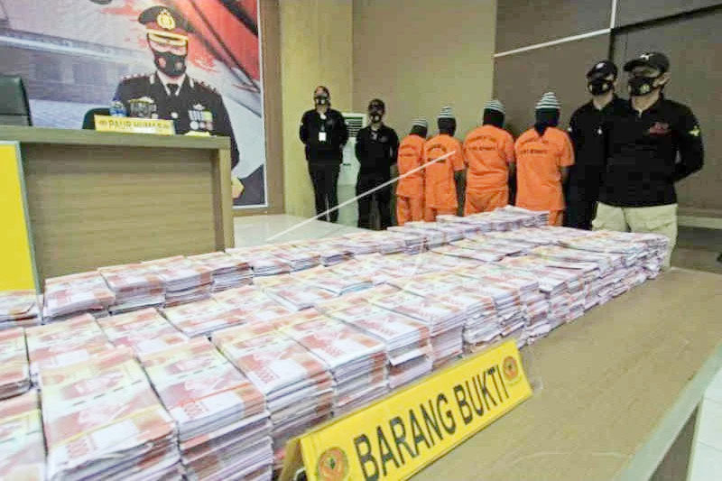 Petugas polisi mengamankan barang bukti uang palsu dan para tersangka di Mapolres Indramayu, Minggu (23/5/2021). Foto: ANTARA/Dedhez Anggara