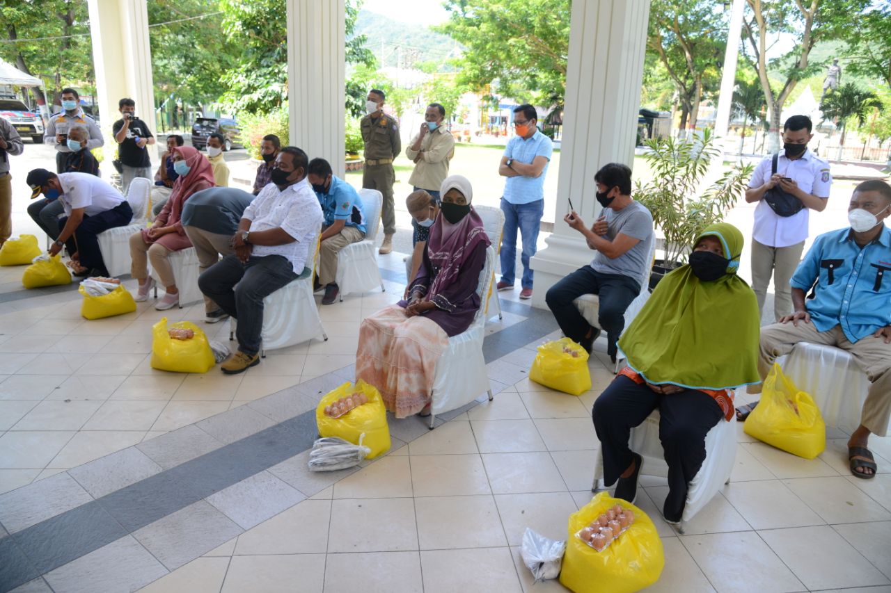 Gubernur Gorontalo Rusli Habibie (kanan) berbincang dengan salah satu operator angkutan kota antar provinsi (AKAP) dan Kepala Dinas Perhubungan Provinsi Gorontalo usai menyerahkan bantuan pangan bersubsidi kepada sopir dan pelaku usaha angkutan darat di t