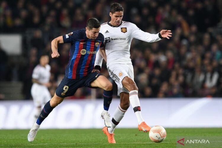 Penyerang Barcelona Robert Lewandowski (kiri) berebut bola dengan bek Manchester United Raphael Varane dalam pertandingan leg pertama babak 32 besar Liga Europa di Camp Nou pada 16 Februari 2023. (ANTARA/AFP/JOSEP LAGO )