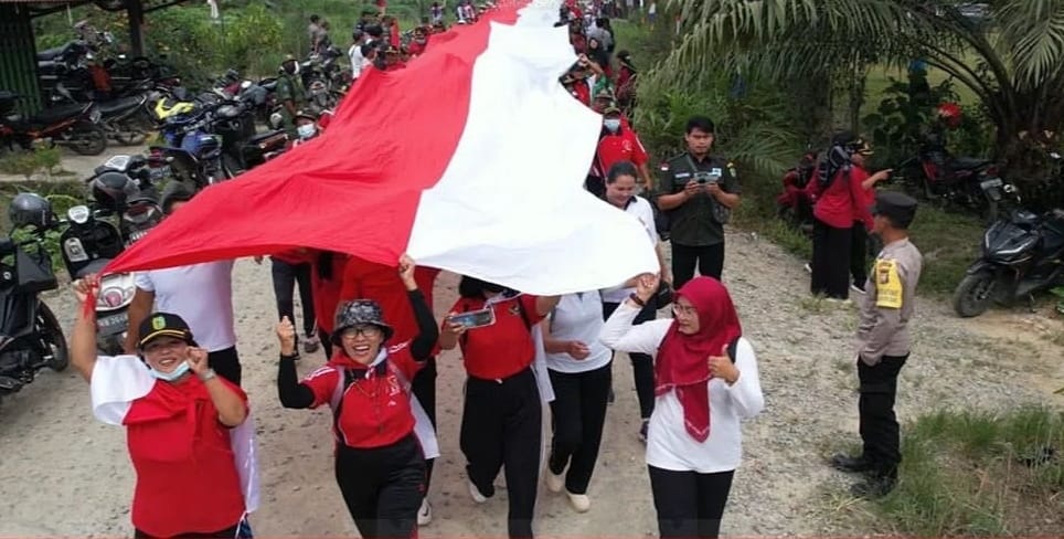 BERKIBAR: Ratusan masyarakat mengibarkan Sang Saka Merah Putih sepanjang 78 meter, di area Bukit Tahang, Desa Serindu, Kecamatan Monterado, kemarin.