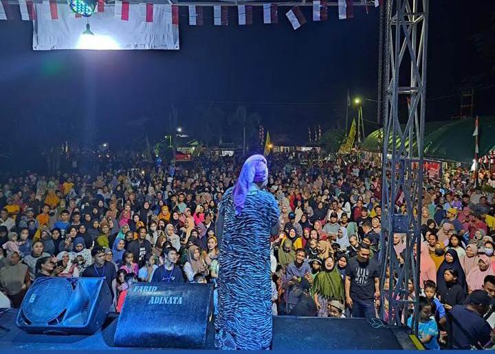 Aksi panggung artis lokal Tante Ragi dalam pesta rakyat di hadapan warga Desa Wajok Hulu.