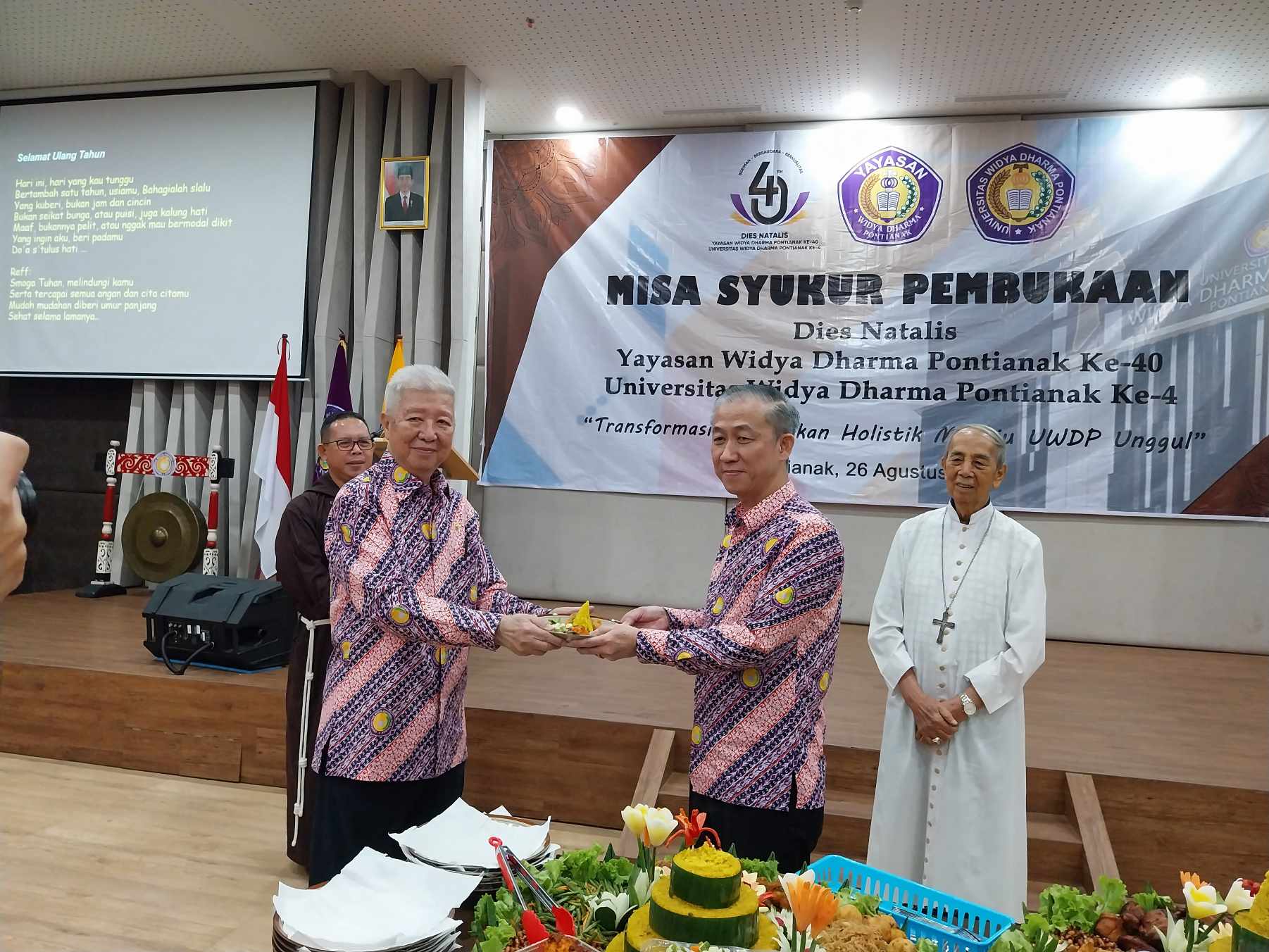 TUMPENG : Penyerahan tumpeng dalam kegiatan Misa Syukur Pembukaan Dies Natalis Widya Dharma
