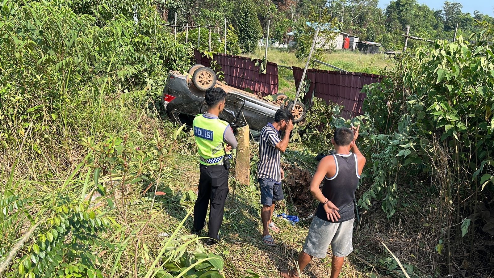 Mobil minibus yang dikemudikan Suria Surbakti kehilangan kendali dan terguling di parit setelah bertabrakan dengan sepeda motor, kemarin.