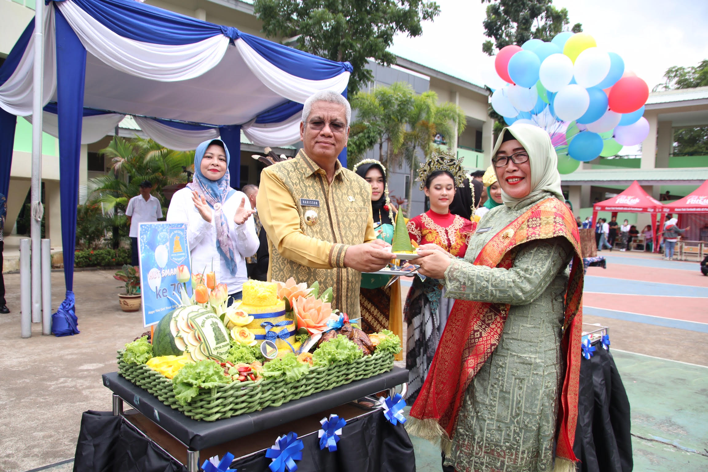 TUMPENG: Pj Gubernur Kalbar Harisson menerima potongan tumpeng saat menghadiri acara peringatan hari jadi ke-70 SMA Negeri 1 Pontianak, Kamis (14/9).